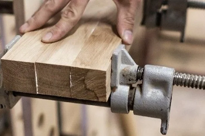 Zwei Holzstücke in einer Schraubzwinge